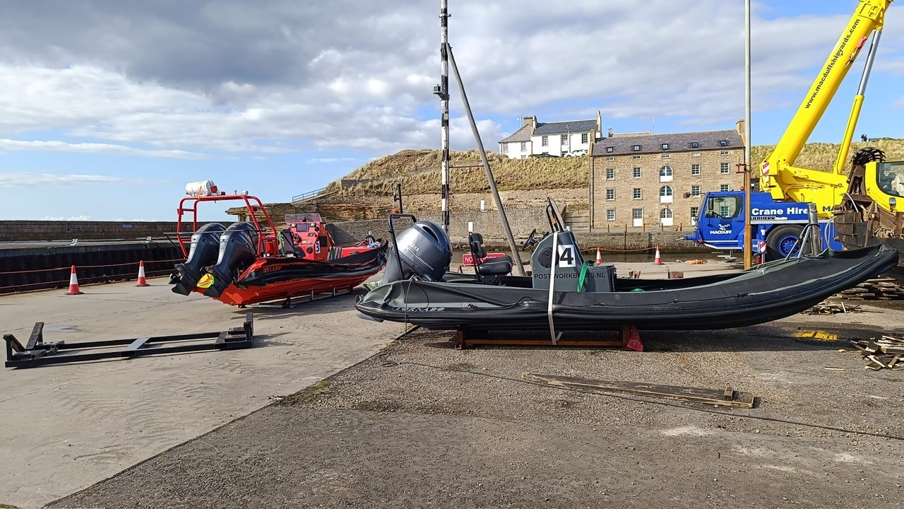 Post Workboats: Twee RIB's op de wal bij Macduff Shipyards in Schotland, mobiele kraan en Tornado-RIB met POSTWORKBOATS.NL op de romp.